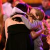 As filhas abraçam a mãe parabenizando-a pelo prêmio