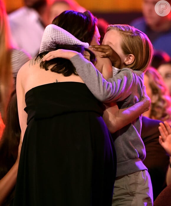 As filhas abraçam a mãe parabenizando-a pelo prêmio