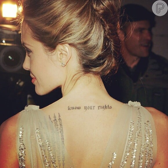Nas costas, a artista tatuou: 'Saiba seus direitos'