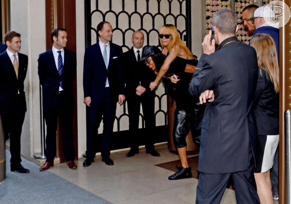 Funcionários do hotel observam a saída de Rihanna