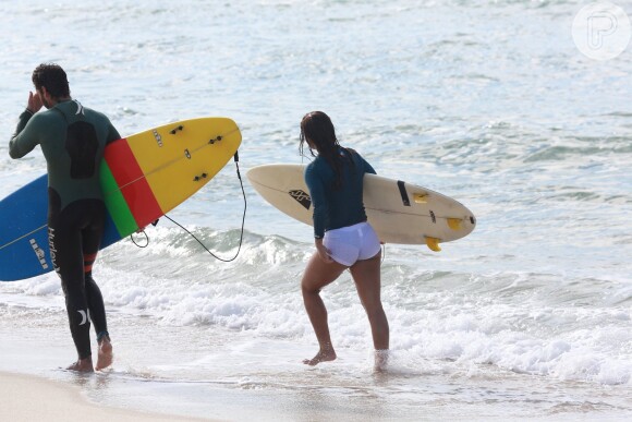 Carol Nakamura deixou a praia, exibindo a boa forma, ao lado do instrutor Rodrigo Robini