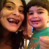 Juliana Paes posa com Pedro, o primogênito, de 2 anos, com os dentes sujos de chocolate no Chá de Bebê de Antônio