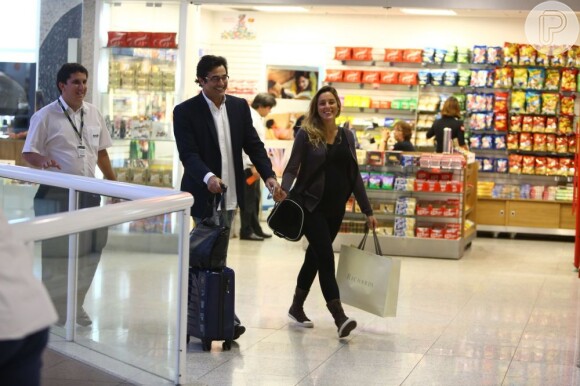 Luciano Szafir e Luhanna Melloni caminham sorridente em aeroporto