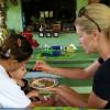 Com ajuda de uma babá, Ana Hickmann alimenta o filho