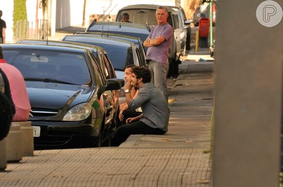 Caio Castro lancha sentado na calçada, antes de gravar para 'Amor à Vida'