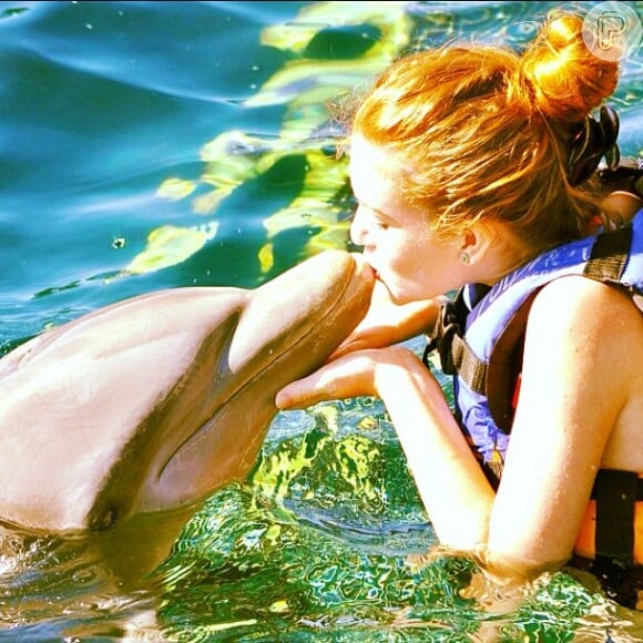Marina Ruy Barbosa faz um coque para beijar um golfinho