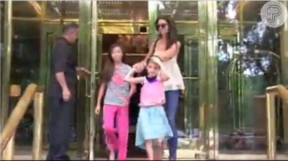 No vídeo, Katie, Suri e uma criança saem de um restaurante e logo são abordadas pelos jornalistas e fotógrafos