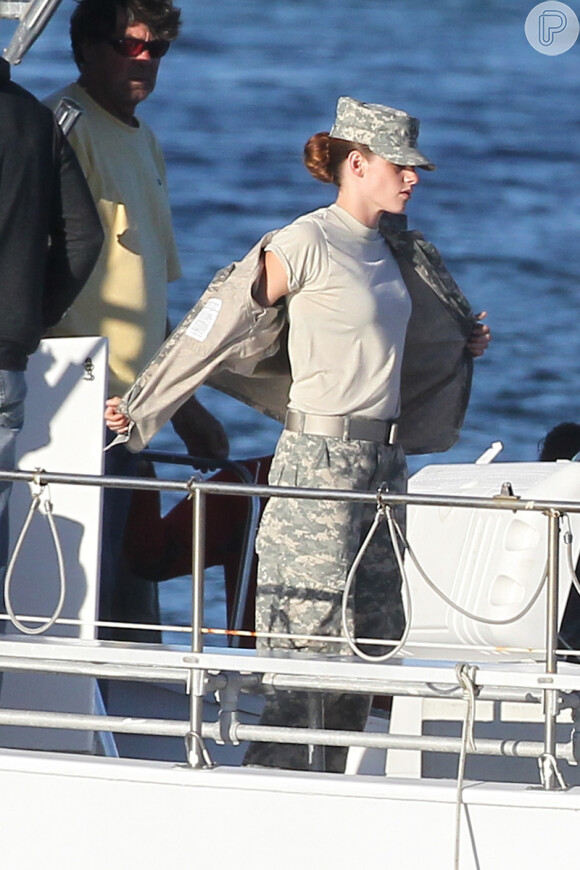 Kristen Stewart tenta matar o calor tirando parta da farda no set de 'Camp X-Ray'