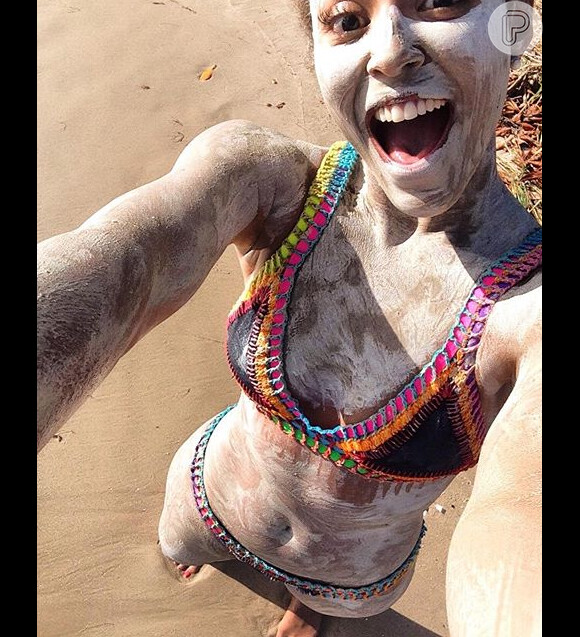 A atriz curtiu o banho de lama na praia