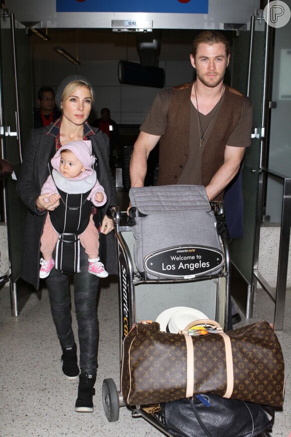 Chris Hemsworth foi visto em aeroporto com a mulher, Elsa Pataky. Dessa vez a mamãe leva a criança e enquanto o marido carrega o carrinho com as bagagens