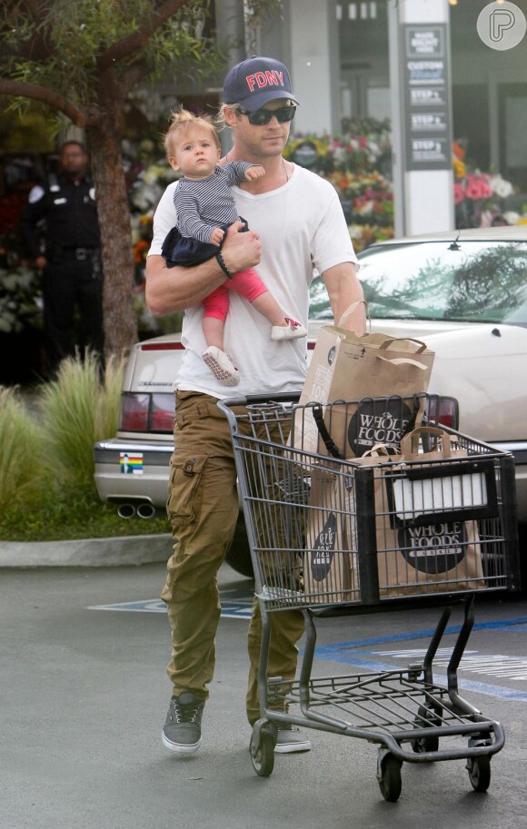 Até na hora das compras Chris Hemsworth conta com a companhia da pequena: com oma mão ele empurra o carrinho cheio de sacolas e com a outra carrega India