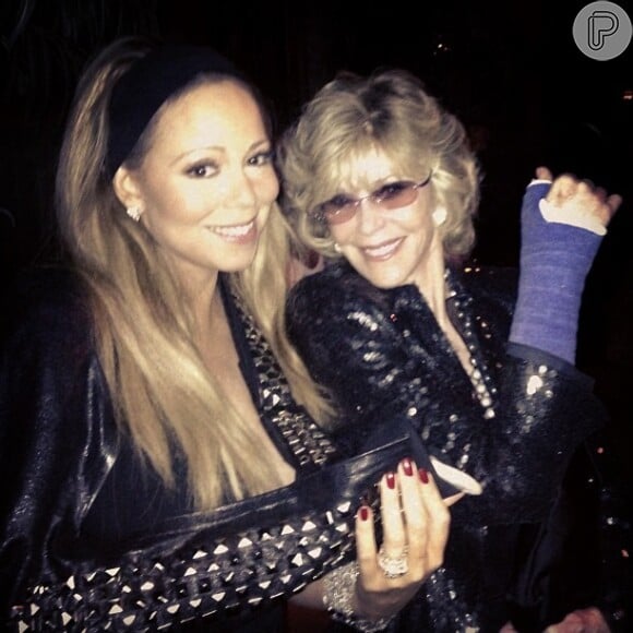Mariah Carey e Jane Fonda posam juntas mostrando os respectivos braços imobilizados