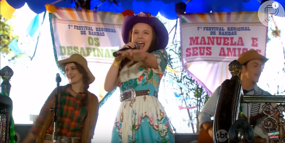 A banda 'Manuela e Seus Amigos' se apresenta no coreto do vilarejo com a preseça de Manuela (Larissa Manoela), na novela 'Cúmplices de um Resgate'
