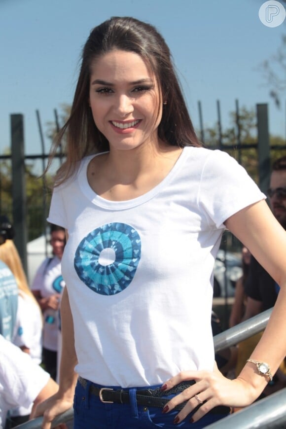 Fernanda Machado posa para fotos com camisa da luta contra o câncer de mama