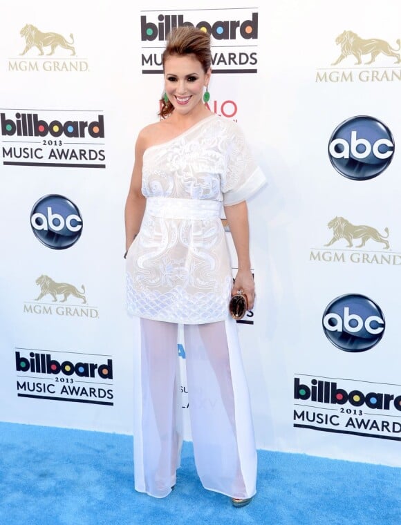 A cantora Alyssa Milano apostou em um vestido branco soltinho de renda, de um ombro só lindo para ir ao Billboard Music Awards, em maio, o problema foi que ela decidiu cobrir as pernas com uma calça no mesmo tom pantalona, deixando o look exagerado