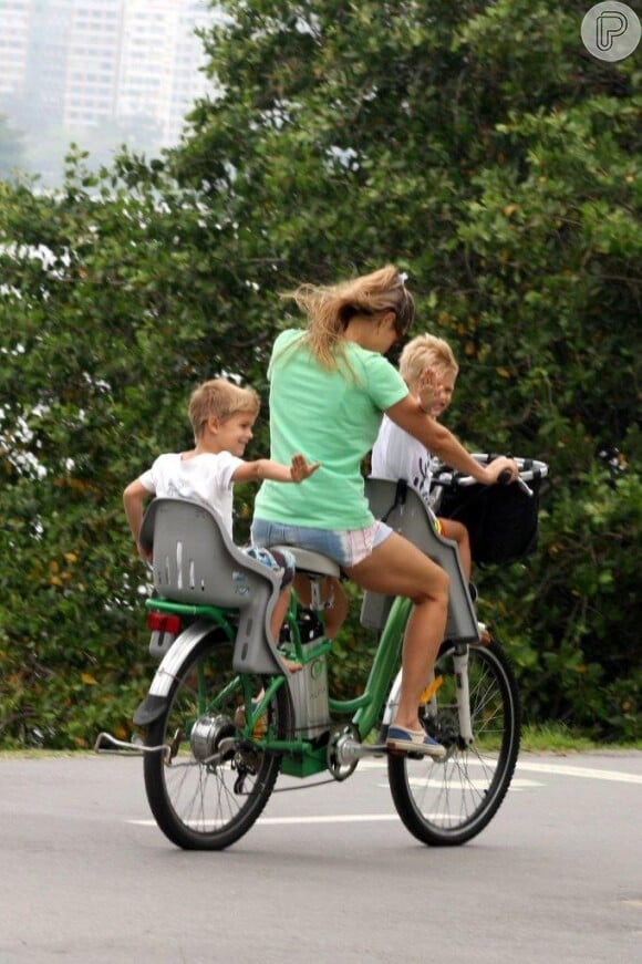 Fernanda Lima carrega os filhos gêmeos de bicicleta