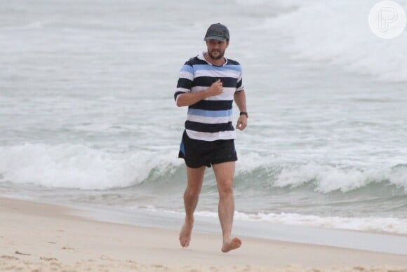 Marcelo Serrado corre pesado na areia humida em Ipanema, no Rio