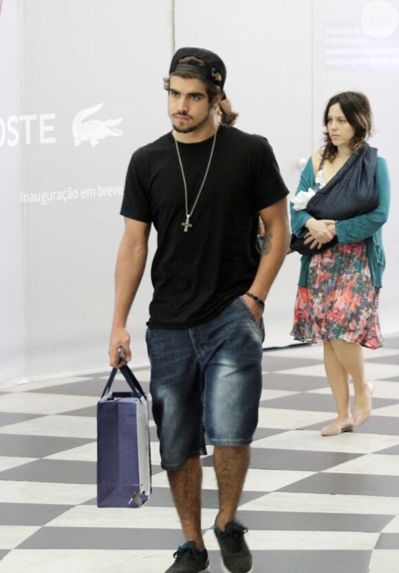 Caio Castro chegou ao aeroporto com apenas uma sacola de papel nas mãos