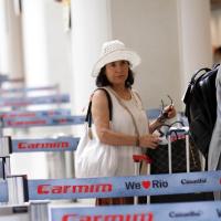 Regina Duarte, de chapéu e óculos escuros, faz foto com fã em aeroporto do Rio