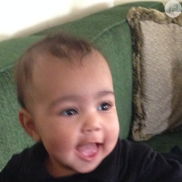 A bebê sorridente da foto é a filha de Kanye West e Kim Kardashian. North West, também conhecida como Nori, nasceu no dia 15 de junho de 2013