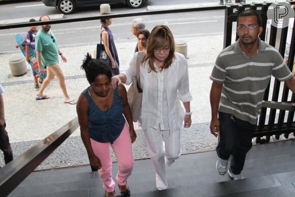 Glória Perez entrou na igreja ao lado de fãs, vestindo branco e muito abatida