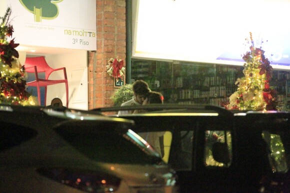 Caio Castro e Maria Casadevall de beijam enquanto esperam o táxi