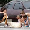 Lavínia Vlasak e seus filhos, Estella e Felipe, fazem carinho no cachorro de Carolina Ferraz na praia do Leblon, Zona Sul do Rio de Janeiro, neste domingo, 15 de dezembro de 2013