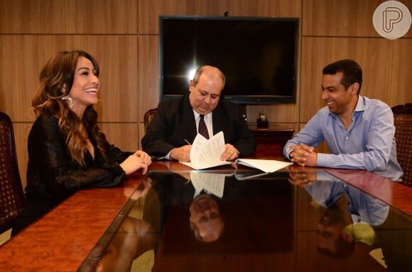 Sorridente, Sabrina Sato formaliza sua ida à TV Record nesta segunda-feira, 16 de dezembro de 2013, ao assinar o contrato na sede da emissora, em São Paulo, na presença de executivos da casa