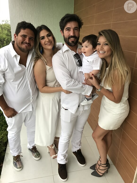 Sandro Pedroso segura o filho, Noah, ao lado da mulher, Jéssica Costa, e dos padrinhos da criança, Lyandra Costa e Rapha Eduardo