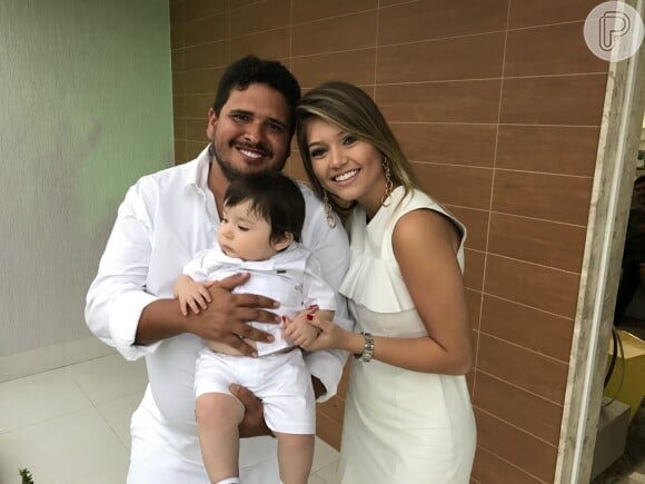 Rapha Eduardo e Lyandra Costa, padrinhos de Noah, neto de Leonardo, posam com a criança durante o batizado