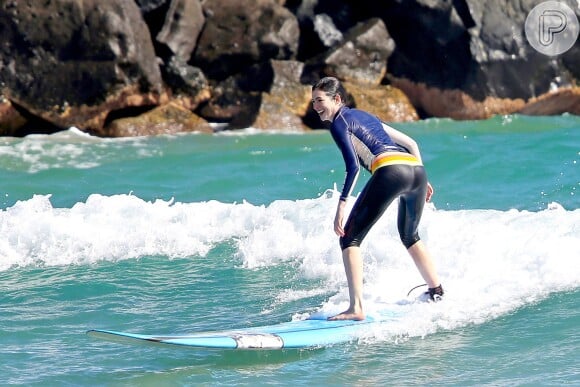 Anne Hathaway aproveitou que o mar estava calmo para surfar