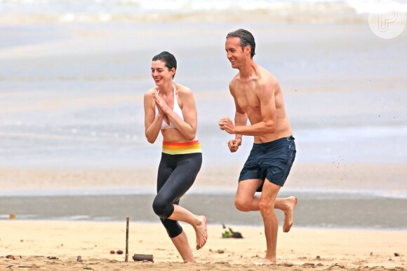 Felizes, Anne Hathaway e Adam Shulman correm em praia do Havaí