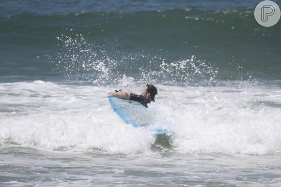 Murilo Benício se esforça para pegar boa onda na praia em dia de mar calmo no Rio