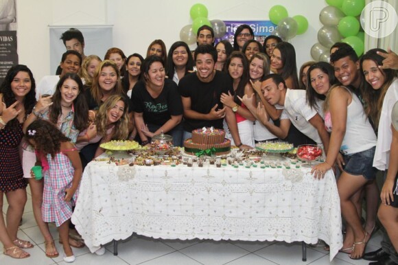 Rodrigo Simas se diverte com as fãs e tira foto na mesa do bolo