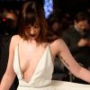 A atriz também usou um deslumbrante vestido Saint Laurent off-white superdecotado na première de 'Cinquenta Tons de Cinza', realizada em Londres, em 12 fevereiro de 2015