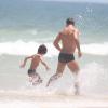 Daniel de Oliveira e seu filho, Raul, de 5 anos, brincam no mar da praia da Barra da Tijuca, Zona Oeste do Rio de Janeiro