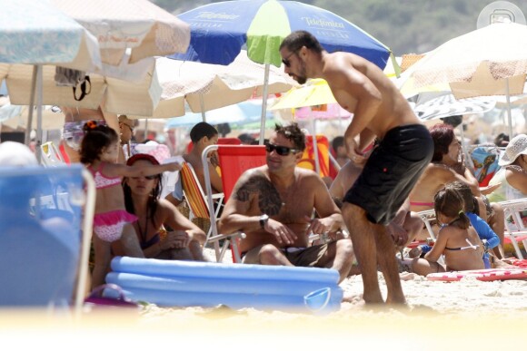 Cauã Reymond curtiu a tarde de domingo com a filha e amigos na praia da Barra da Tijuca