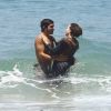 Caio Castro e Leticia Colin trocam carinhos no mar do Grumari