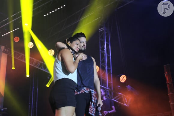 Luan Santana posa ao lado da fã em cima do palco durante show