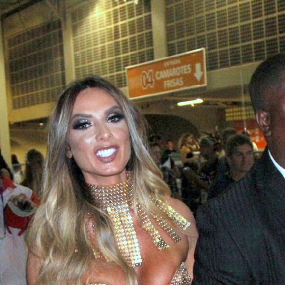 Com um superdecote, Nicole Bahls é amparada por seguranças até o camarote