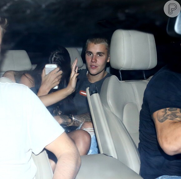 A mão da loira tentou cobrir o rosto da morena na saída com Justin Bieber