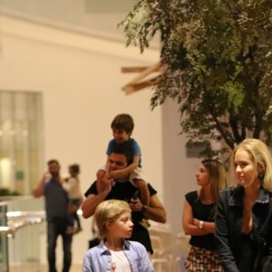 Angélica, de muleta rosa, apostou em um vestido preto e deixou a bota ortopédica mais discreta