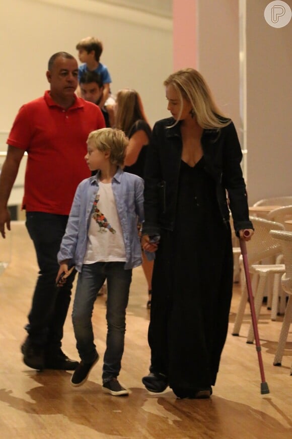 De muleta rosa, Angélica deixa shopping com o filho Benício