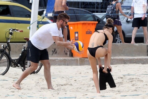 Fernanda Lima veste short enquanto Rodrigo Hilbert se prepara para jogo de vôlei