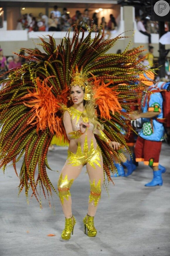Monique Alfradique samba com fantasia que representa o Sol no desfile pela Grande Rio