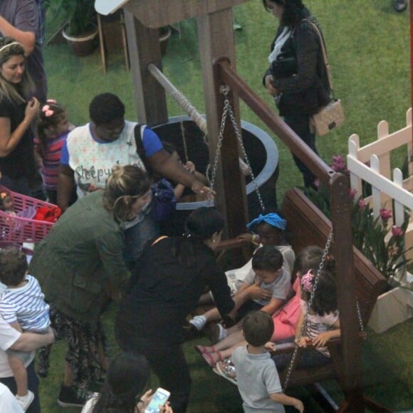 Títi brinca com outras crianças em balanço