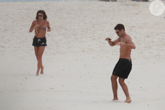 Cauã Reymond fez exercícios pela areia da praia enquanto esperava a namorada, Mariana Goldfarb