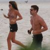 Cauã Reymond e a namorada, Mariana Goldfab, correram lado a lado pelas areias da praia da Barra da Tijuca