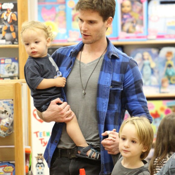 Jonatas Faro carrega primo no colo em loja de brinquedos