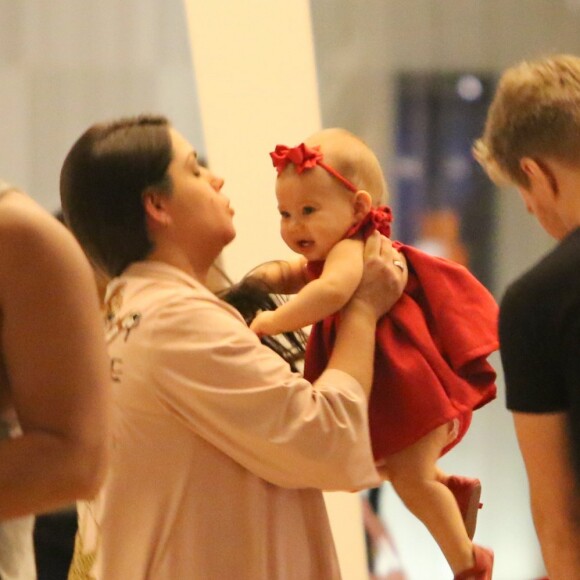 Grávida, Thais Fersoza pega a filha, Melinda, no colo, em passeio